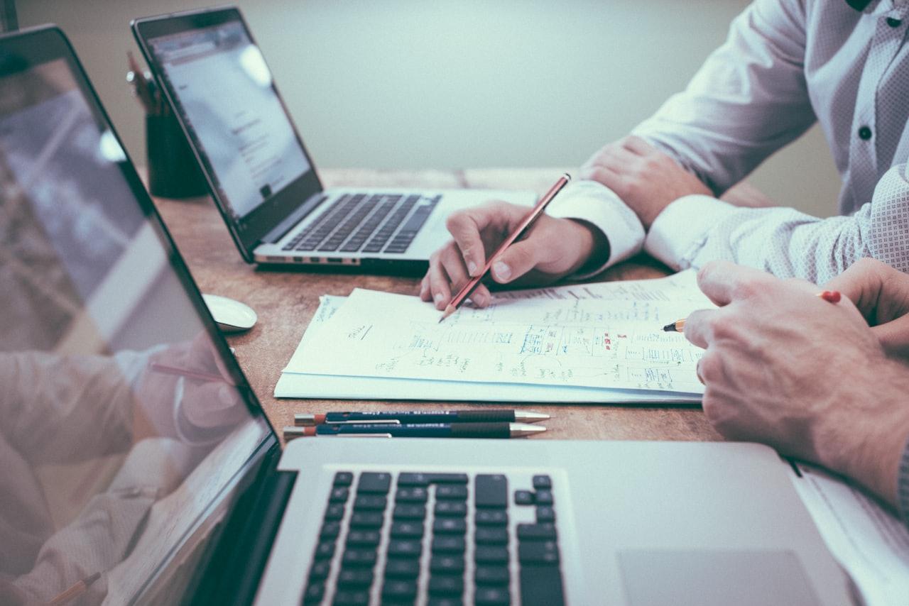 Consultants reviewing project documents and financial plans at a desk