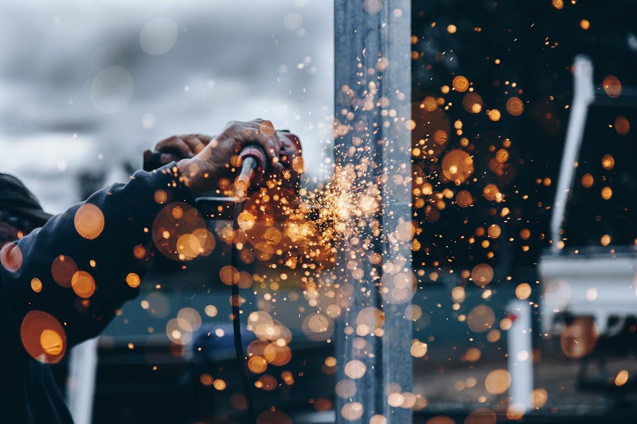 Worker grinding metal with sparks flying on a worksite